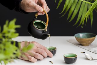 Man pouring tea teacup