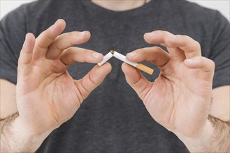 Mid section man s hand breaking cigarette