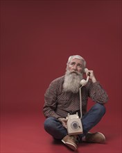 Old man holding telephone