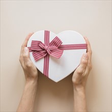 Person holding gift box heart shape
