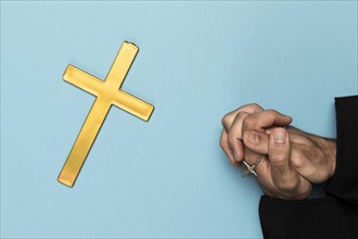 Priest praying with wood cross