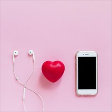 Red heart earphone smartphone pink background