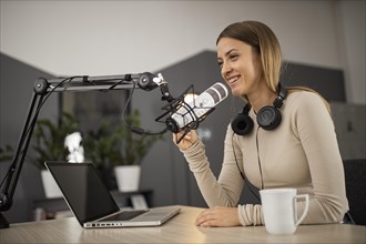 Smiley woman doing podcast radio with microphone laptop