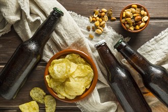 Top view beer bottles with chips nuts