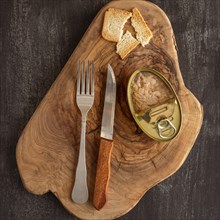 Top view tuna can wooden board with cutlery