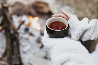 Woman holding hot cup tea outdoors