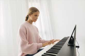 Young girl playing keyboard instrument home