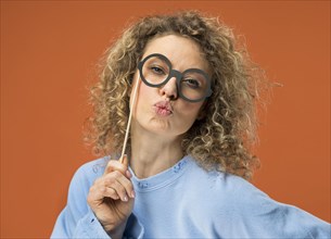 Young woman having fun with fake glasses