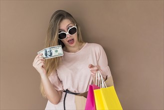 Amazed woman standing with shopping bags money
