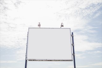Big empty billboard with two lamp against sky