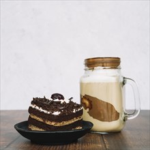 Chocolate smoothie jar with slice cake wooden table