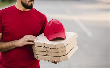 Close up delivery guy holding pizza boxes