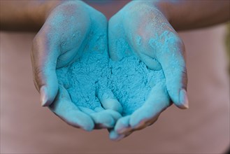 Close up hands holding blue powder