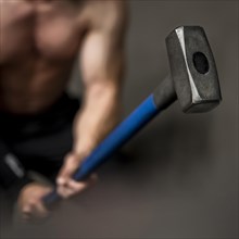 Close up man training with hammer