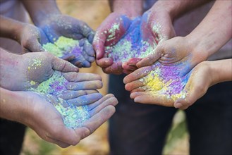 Close up multiple hands holding powder color