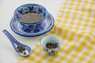 Close up oolong tea cup with spoon tablecloth against white background