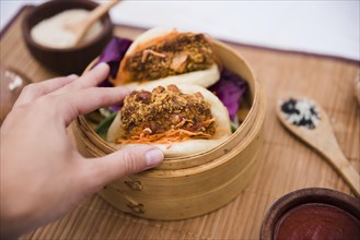 Close up person s hand holding taiwan s traditional food gua bao steamer