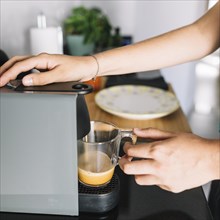 Close up woman taking coffee from coffee machine