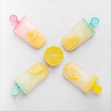 Composition cut lemon ice popsicle with citrus colorful sticks