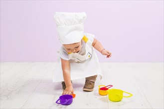 Cook child playing with toy dishes