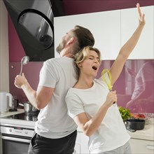 Couple indoors singing kitchen together