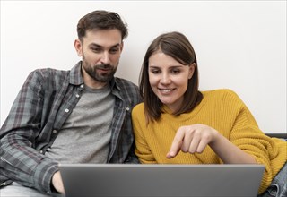 Couple using laptop home