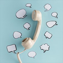 Flat lay chat bubbles with telephone receiver