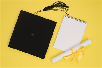 Flat lay festive graduation arrangement with empty notepad