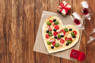 Flat lay heart shaped pizza with ring