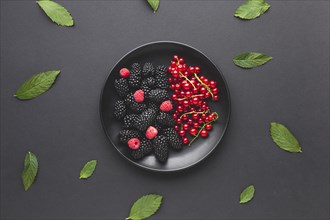 Flat lay plate fresh berries with leaves
