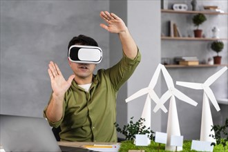 Front view man working eco friendly wind power project using virtual reality headset