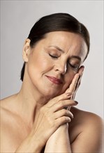 Front view mature woman posing with make up eyes closed