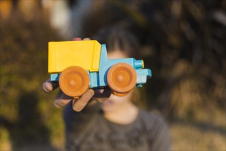 Girl holding toy car front her face