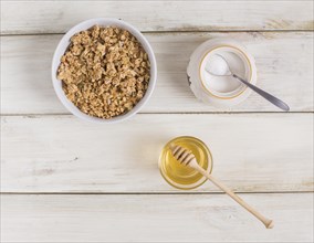 Granola with pumpkin seeds powdered milk jar honey wooden table