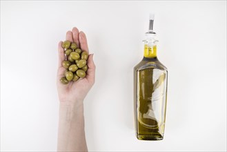 Hand holding olives bottle oil