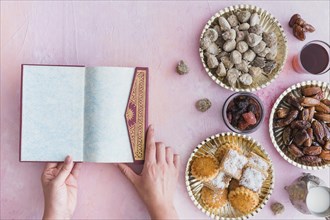 Hands with koran table with sweets