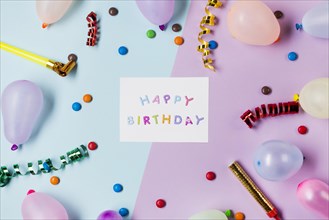 Happy birthday message blue pink surrounded with streamers gems balloons colored backdrop