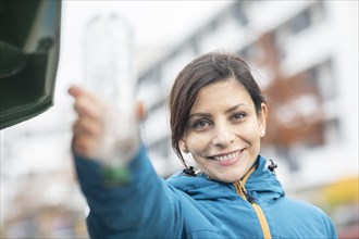 Woman disposes of plastic bottle in the city