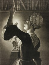 Woman with a candle lamp takes a book from the shelf