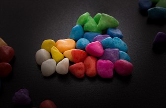 Pile of little colorful pebbles on black background