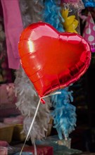 Little red color heart shape balloon in a bazaar