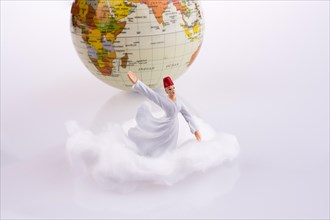 Sufi dervis on a white cloud near globe