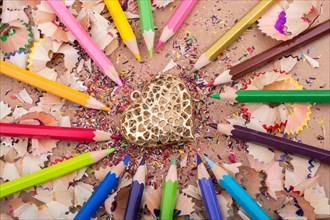 Heart shaped object amid color pencils and its shavings