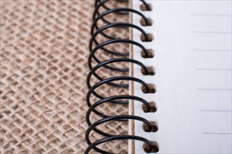 Brown color spiral notebook placed on a canvas background