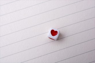 Colorful cube with a heart placed on paper