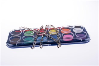Watercolour paint set in chains on a white background