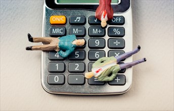 Men figurine on Calculator device with a keyboard and display