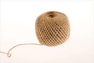 Roll of brown color linen string on a white background