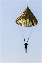 Parachuting sport concept. Skydiver descending with a parachute