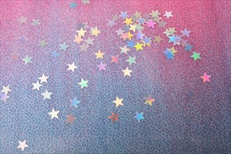 Colorful confetti stars on a gold colorful background